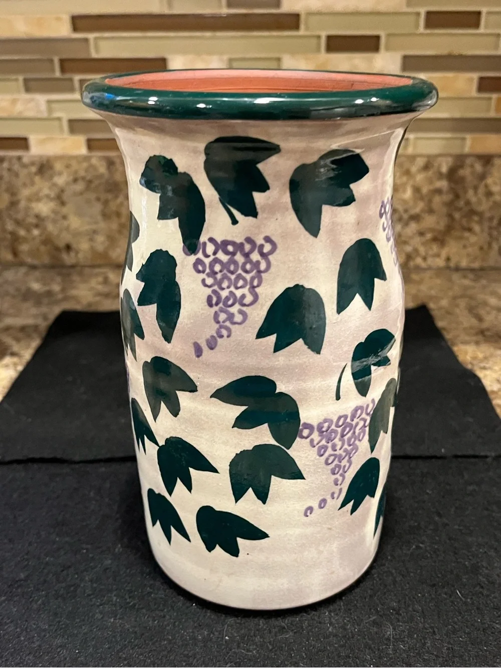 Handmade pottery vase cream-colored with a green and purple grape vine motif
